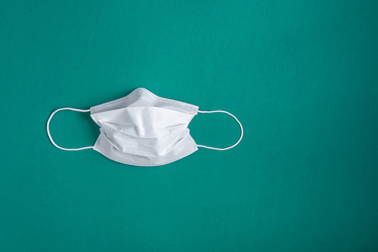 Photo gratuit masque chirurgical sur fond vert minimaliste