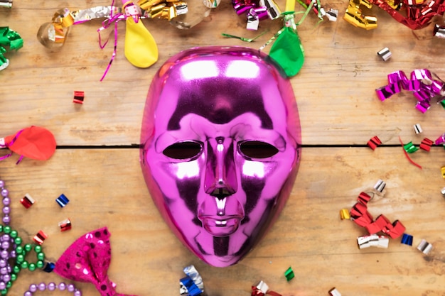 Masque magenta près de trucs de fête