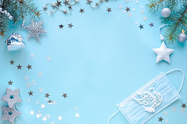 Masque médical et décorations de Noël sur surface bleue