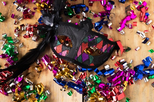 Photo gratuite masque noir sur les confettis