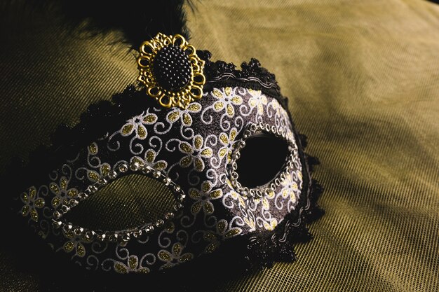 masque vénitien gris sur un tissu jaune