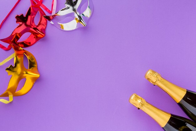 Masques de carnaval colorés avec des bouteilles de champagne