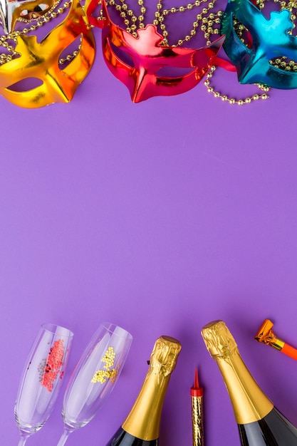 Masques de carnaval colorés avec des bouteilles de champagne