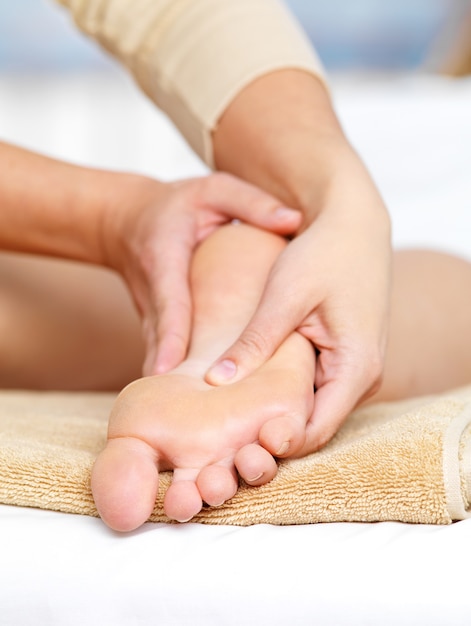 Photo gratuite massage gros plan pour les pieds dans le salon spa - vertical