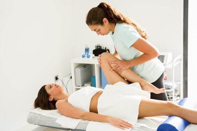Massage médical à la jambe dans un centre de physiothérapie.
