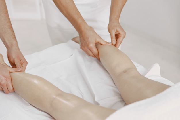 Le massage à quatre mains. Concept de soins de santé et de beauté féminine. Deux masseuses font un double massage d'une fille. Femme dans un salon de spa.