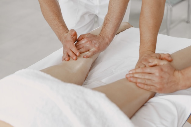 Le massage à quatre mains. Concept de soins de santé et de beauté féminine. Deux masseuses font un double massage d'une fille. Femme dans un salon de spa.