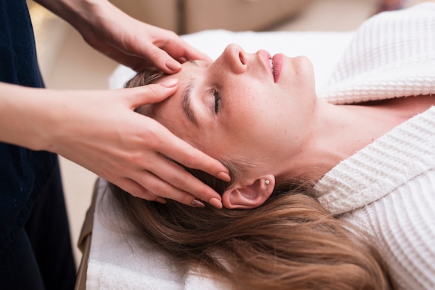 Photo gratuite massage de la tête sur une femme détendue au spa