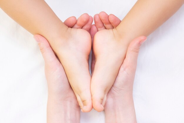Masseur Massant Le Pied D Un Petit Enfant La Mere Fait Un Massage Sur Son Pied De Bebe Prevention Des Pieds Plats Developpement Tonus Musculaire Photo Premium