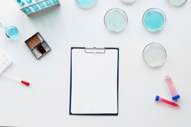 Photo gratuite matériel de laboratoire à plat et presse-papiers