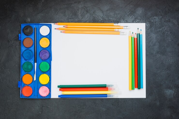 Photo gratuit matériel de peinture sur une feuille de papier blanc sur fond noir