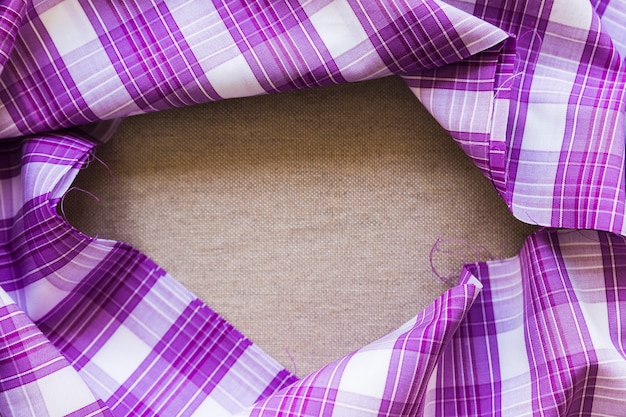 Photo gratuite matière de tissu à motif à carreaux violet formant cadre