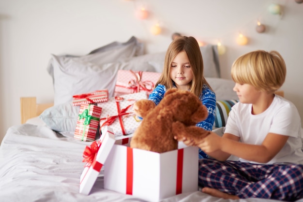 Matin ouvert des cadeaux de Noël dans le lit