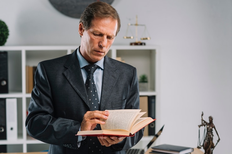 Photo gratuit mature avocat tournant les pages du livre de droit dans la salle d'audience