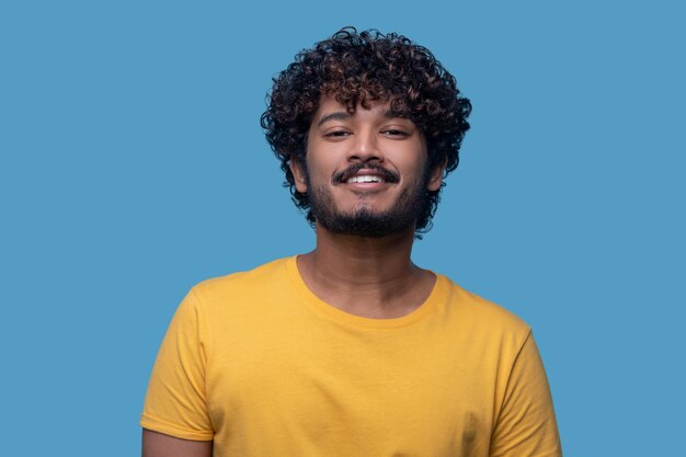 Mec aux cheveux noirs mignon avec une expression heureuse à l'avenir