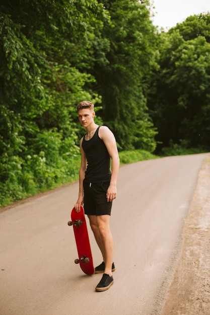 Photo gratuite mec complet avec skateboard à l'extérieur