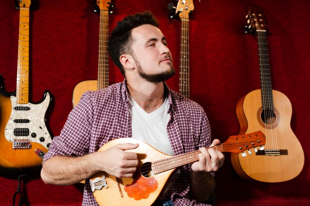 Mec jouant à la mandoline en studio