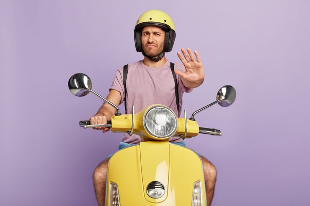 Mec mécontent avec casque de conduite scooter jaune