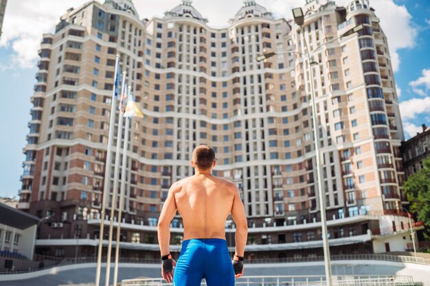 Mec musclé posant à l'extérieur. Portrait d'un short bleu bel homme.