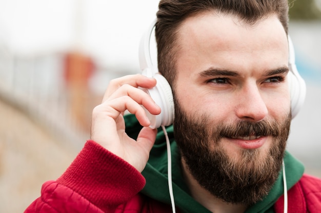 Photo gratuite mec smiley gros plan avec un casque à la recherche de suite