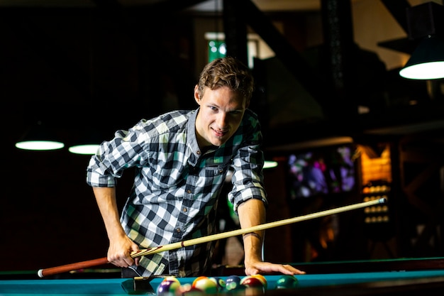 Mec souriant avec une queue de billard