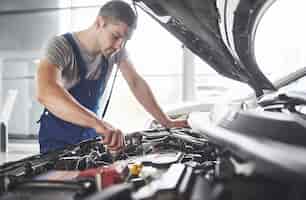 Photo gratuite mécanicien automobile travaillant dans le garage. service de réparation.