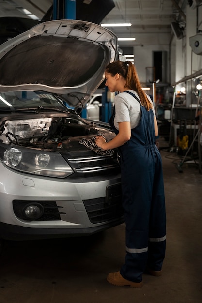 Mécanicien féminin travaillant dans le magasin sur une voiture