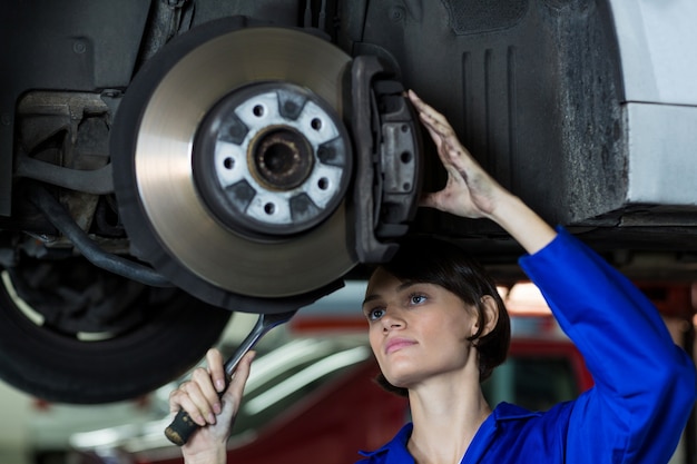 mécanicien Femme fixant un frein à disque de roue de voiture