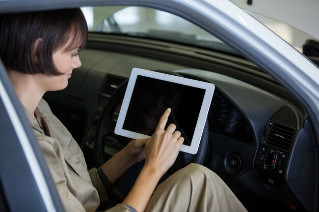 mécanicien Femme utilisant tablette numérique dans la voiture