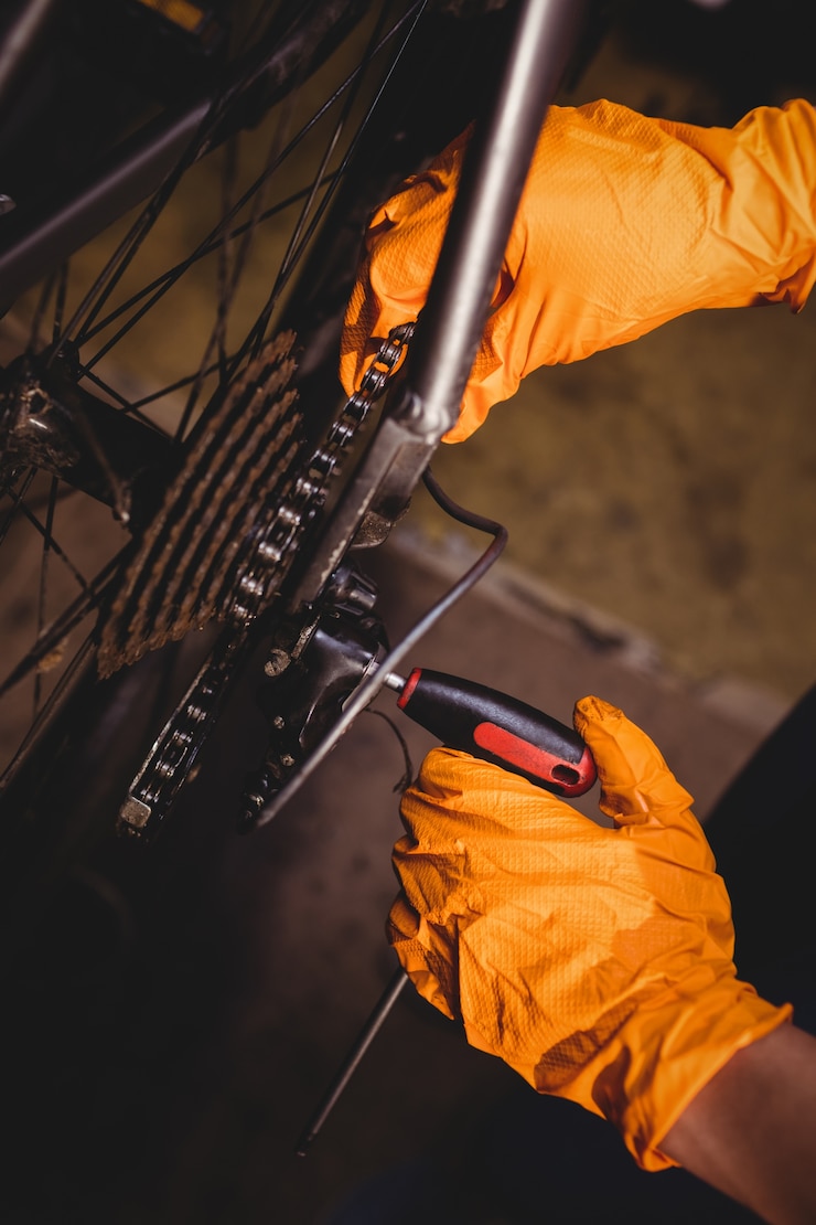 Photo gratuit un mécanicien réparant un vélo.