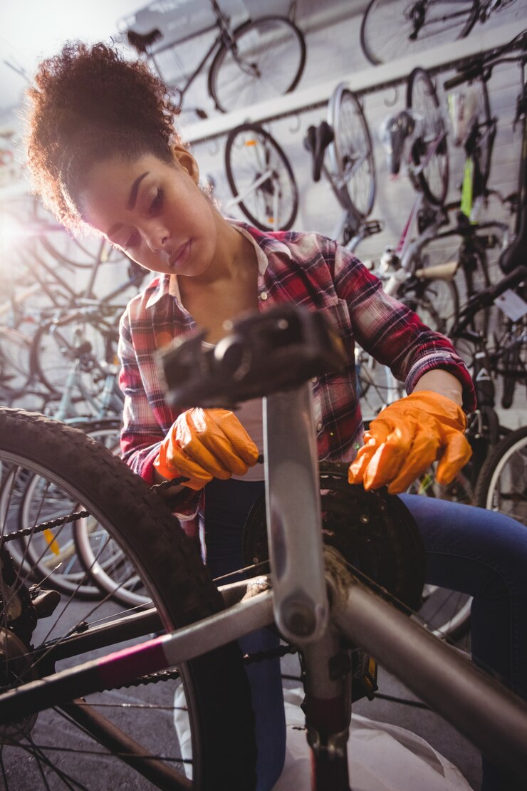 Photo gratuit un mécanicien réparant un vélo.