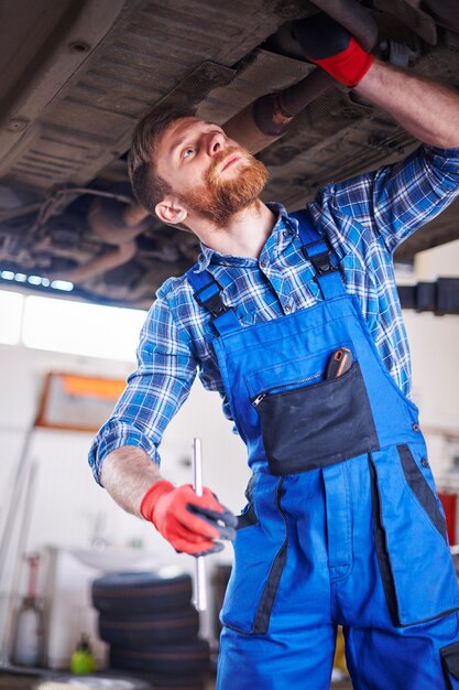 Mécanicien réparant une voiture dans l'atelier