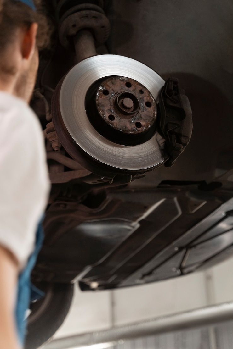 Photo gratuit mécanicien travaillant dans l'atelier sur une voiture