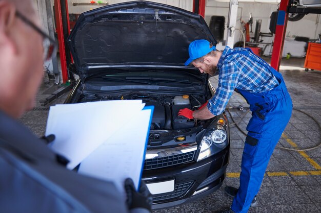 Mécaniciens réparant une voiture dans l'atelier