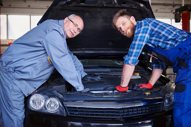 Mécaniciens réparant une voiture dans l'atelier