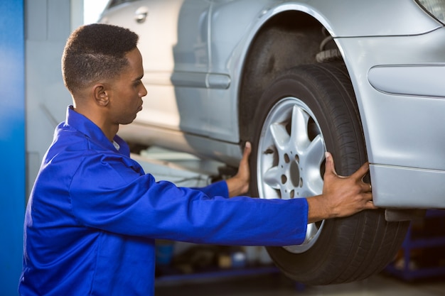 Photo gratuite mechanic fixation d'un pneu de voiture