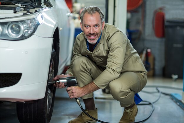 Mechanic la fixation d&#39;une roue de voiture avec une clé pneumatique