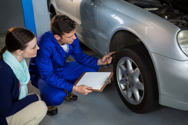 Mechanic montrant client le problème avec la voiture