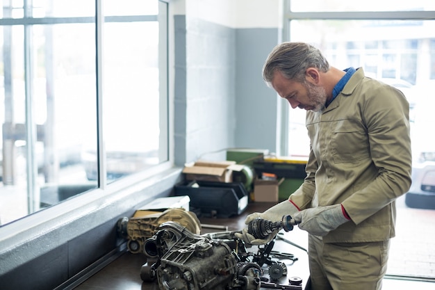 Mechanic vérifier une des pièces de voiture