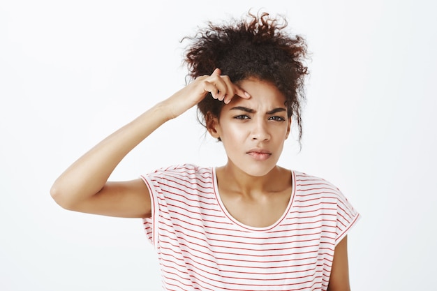 mécontent femme bouleversée avec une coiffure afro posant dans le studio