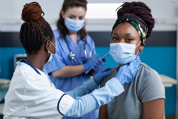 Médecin afro-américain mesurant le pouls cardiaque tout en