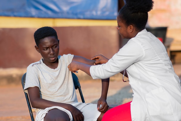 Médecin d'aide humanitaire en Afrique prenant soin d'un patient
