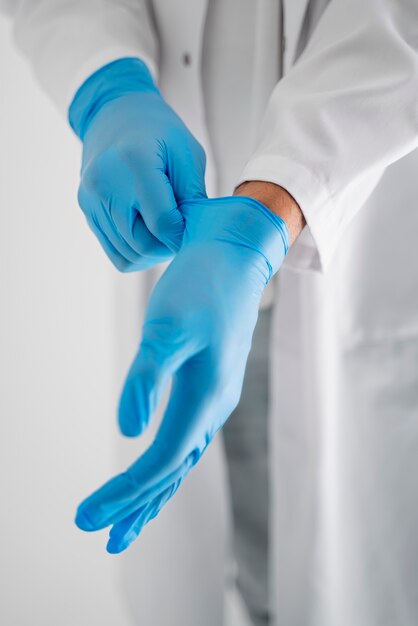 Médecin à angle élevé mettant des gants
