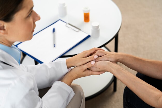 Médecin à angle élevé tenant les mains du patient