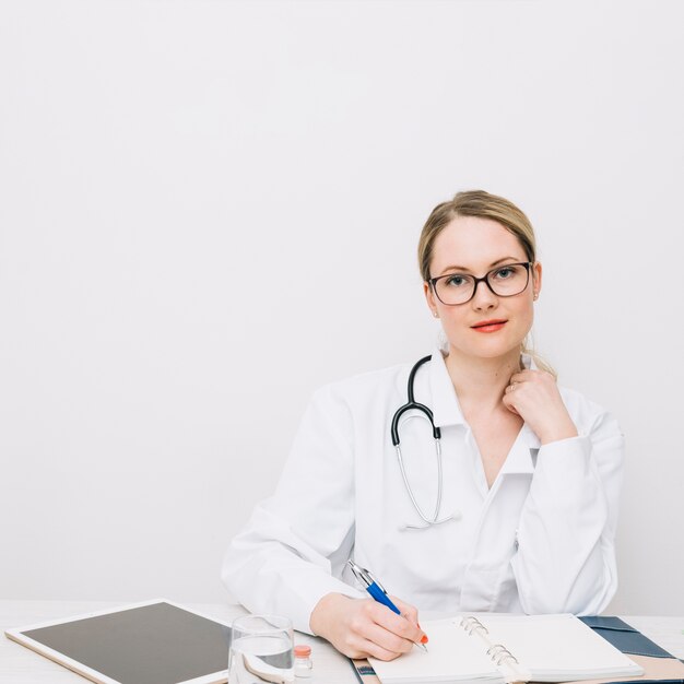 Médecin au bureau en regardant la caméra