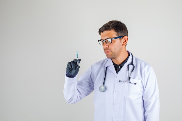 Médecin En Blouse Blanche Avec Stéthoscope Tenant La Seringue