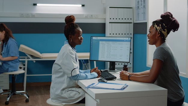 Médecin consultant un jeune patient lors d'une visite de contrôle pour des soins de santé au cabinet. Femme souffrante parlant au médecin du traitement de guérison et de la consultation. Travailleur médical à l'examen