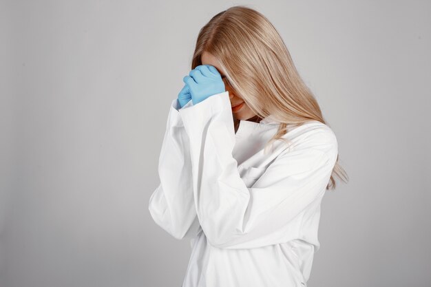 Médecin dans un masque médical. Thème du coronavirus. Isolé sur un mur blanc. Priez pour les médecins.