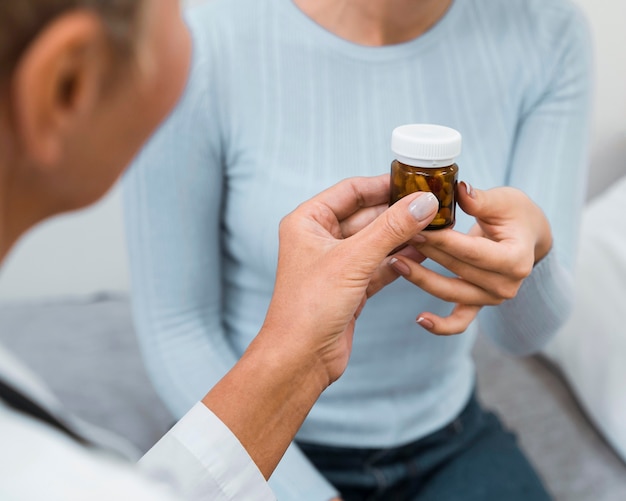 Médecin donnant une bouteille de pilules à un patient