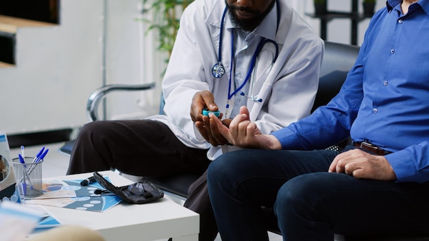Photo gratuite un médecin est assis avec un patient et un médecin vérifie la couleur bleue de la main.
